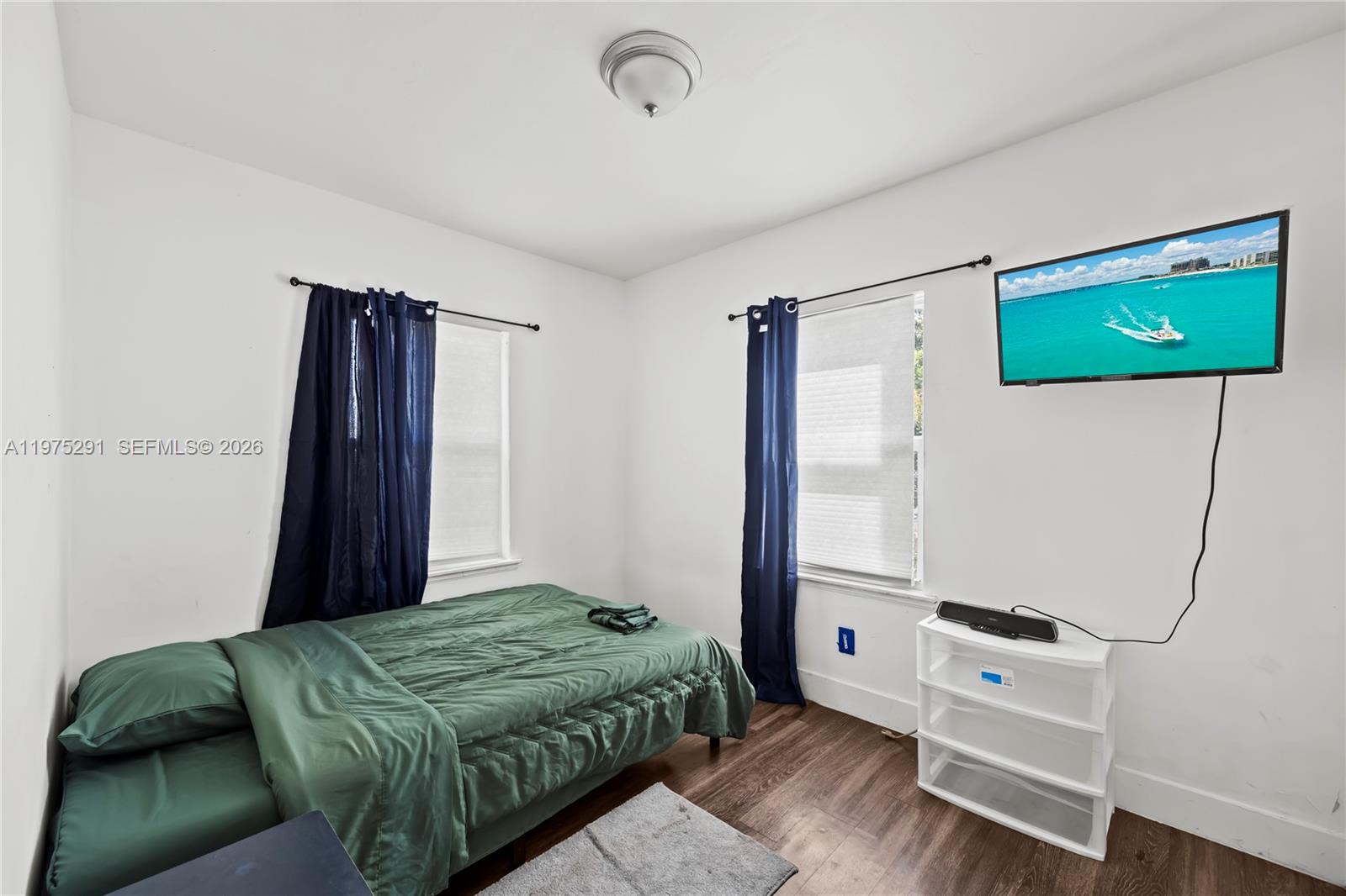 919 Northwest 66th Street Miami, FL 33150 - Photo 16 of 21 a bedroom with a bed and a flat tv screen on the dresser