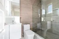 a white toilet sitting next to a bathroom sink
