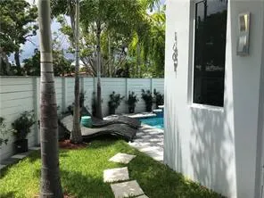 a view of a patio with chairs potted plants and a palm tree