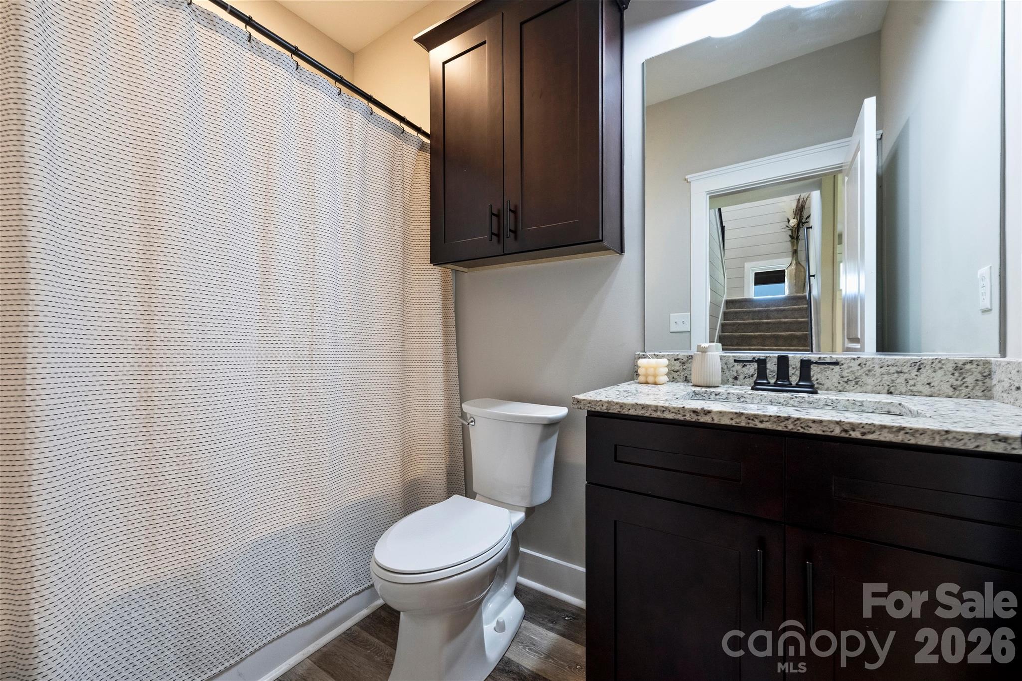 606 Elm Street Locust, NC 28097 - Photo 11 of 23 a bathroom with a granite countertop sink toilet and mirror