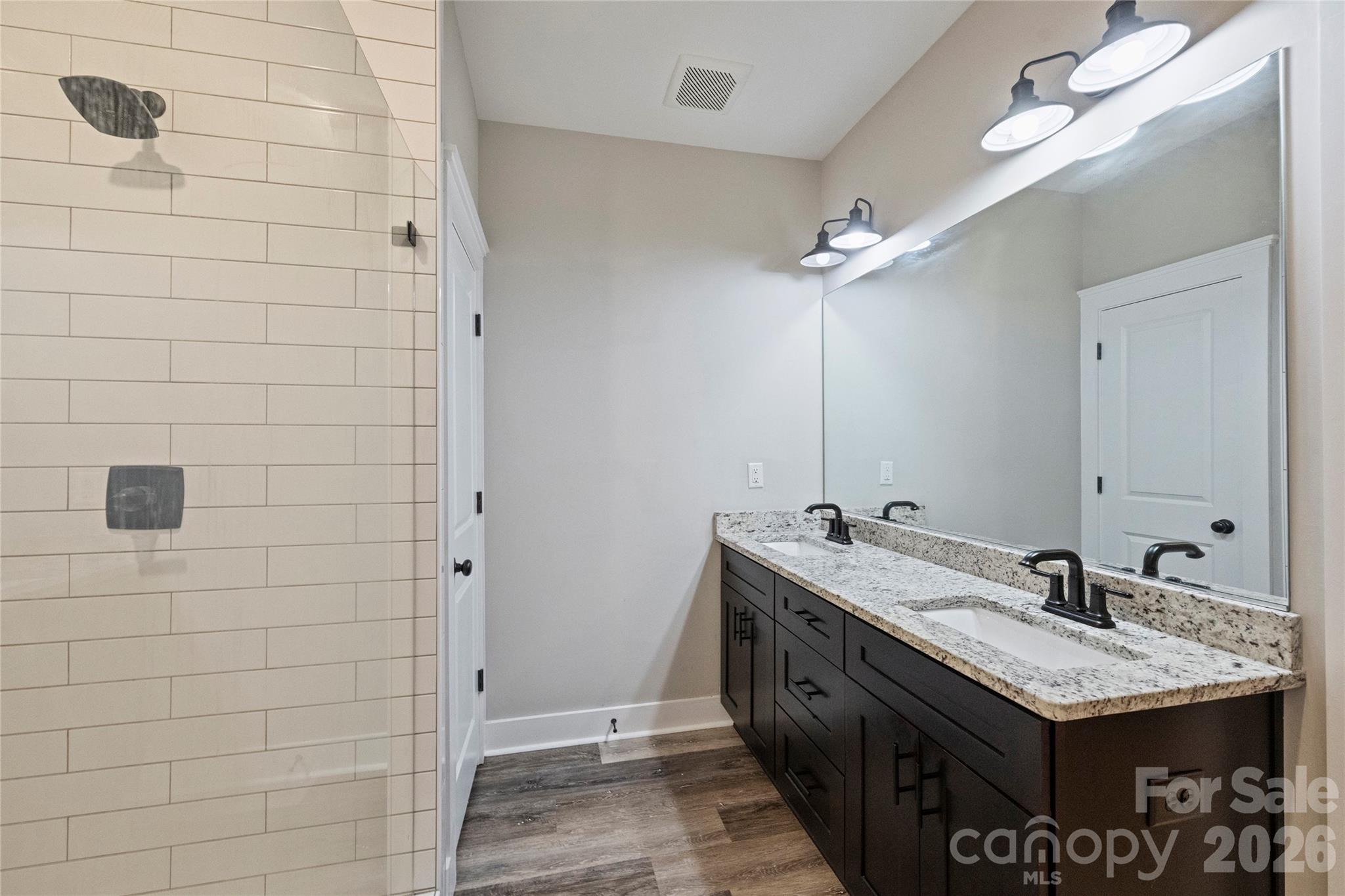 606 Elm Street Locust, NC 28097 - Photo 16 of 23 a spacious bathroom with a granite countertop sink a mirror and shower