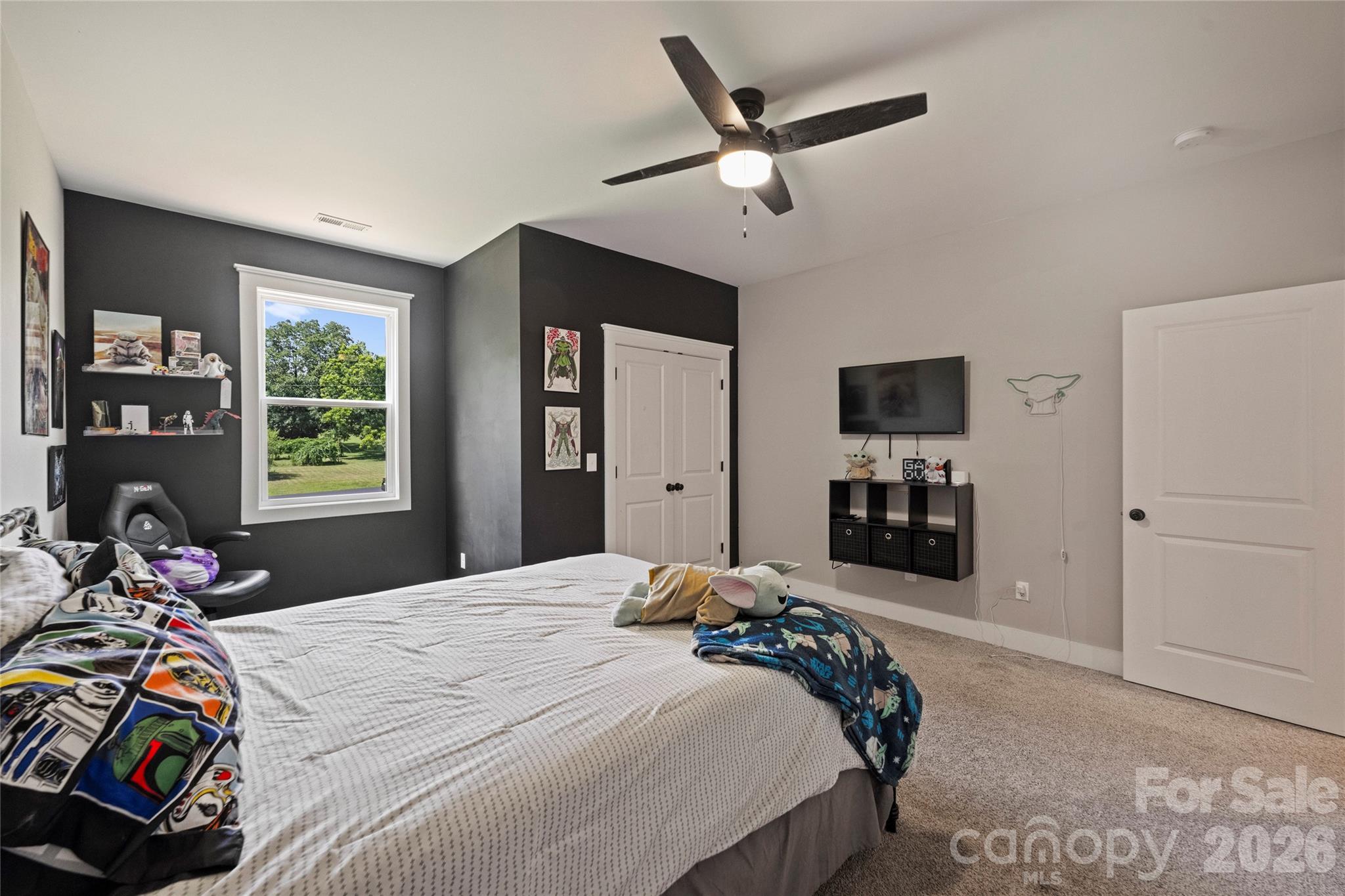 606 Elm Street Locust, NC 28097 - Photo 20 of 23 a bedroom with a bed a dresser and flat screen tv