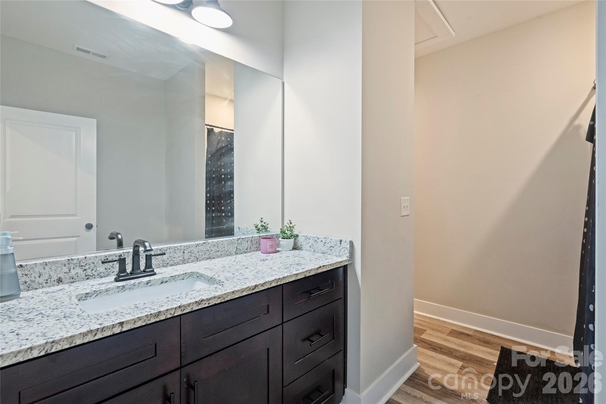 606 Elm Street Locust, NC 28097 - Photo 21 of 23 a bathroom with a granite countertop sink and a mirror