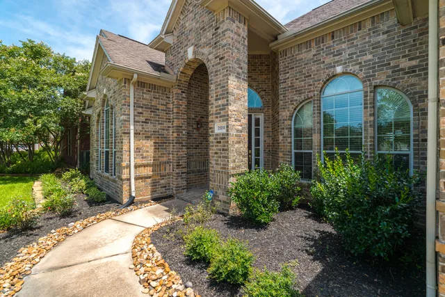 a front view of a house with a yard and potted plants