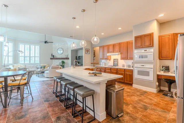 a large kitchen with stainless steel appliances granite countertop a sink and cabinets
