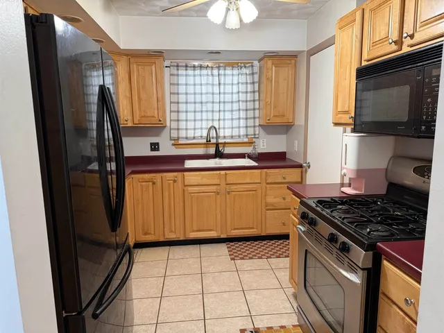 a kitchen with stainless steel appliances a sink stove refrigerator and a window