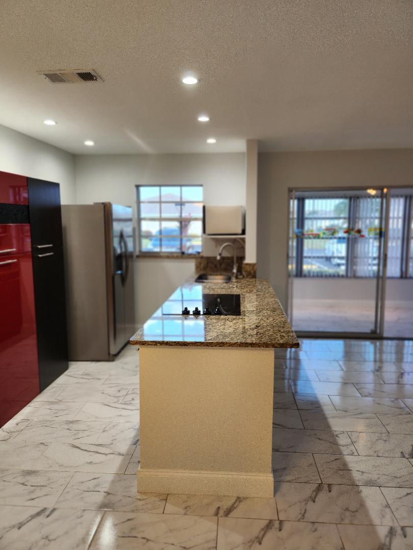 5433 Lakefront Boulevard, Unit B Delray Beach, FL 33484 - Photo 12 of 13 a kitchen with stainless steel appliances granite countertop a sink stove and refrigerator