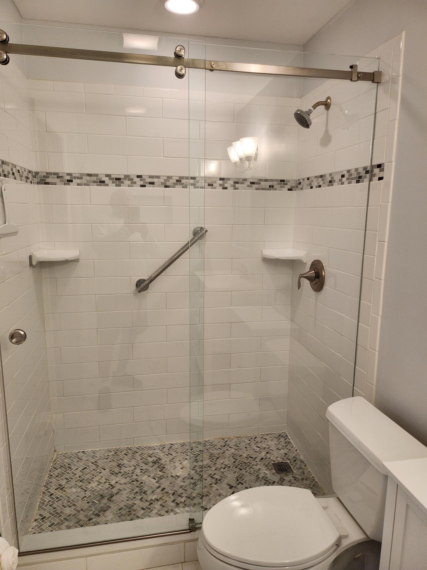 5433 Lakefront Boulevard, Unit B Delray Beach, FL 33484 - Photo 3 of 13 a bathroom with a shower a toilet and a shower
