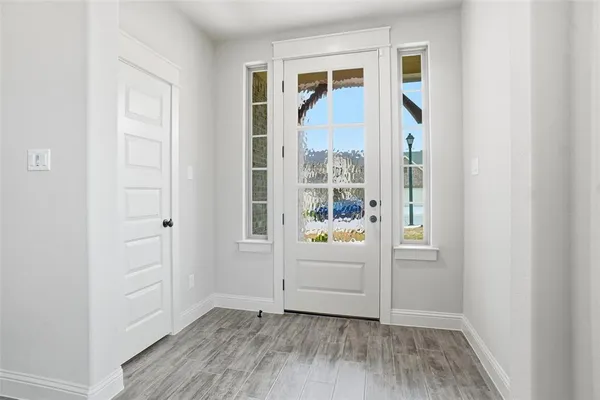 an entryway with wooden floor and cabinet