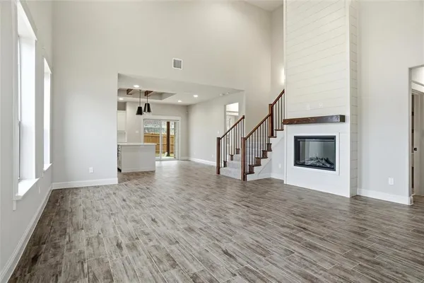 a view of empty room with wooden floor and fireplace