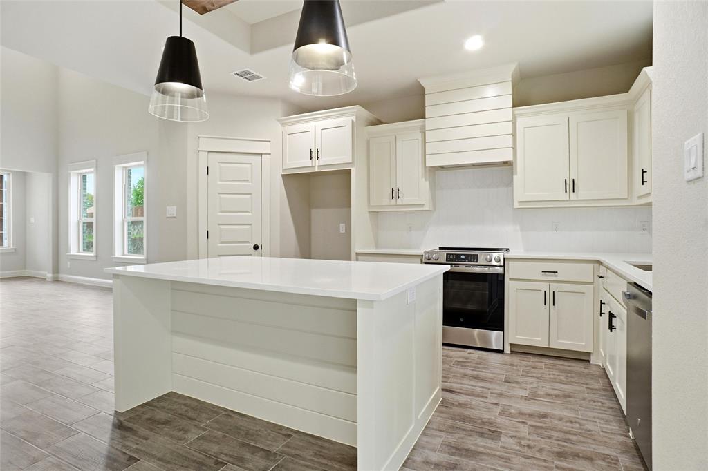 201 Legacy Boulevard Weatherford, TX 76085 - Photo 8 of 25 a kitchen with a stove a sink and a refrigerator