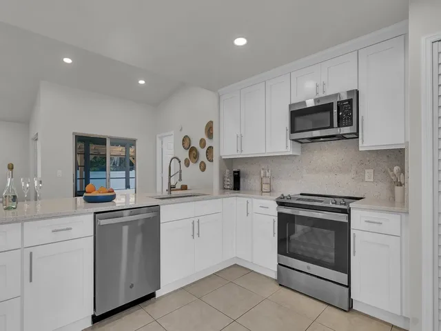 a kitchen with white cabinets and stainless steel appliances