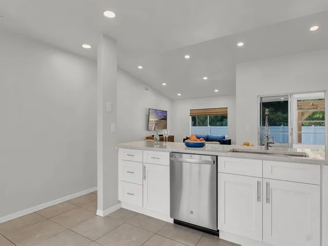 a kitchen with white cabinets and white appliances