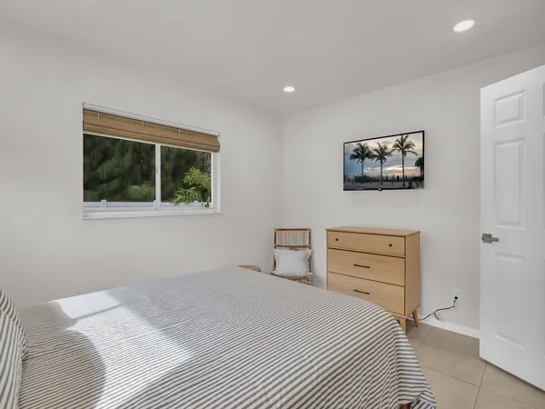 a bedroom with a bed and a painting on the wall