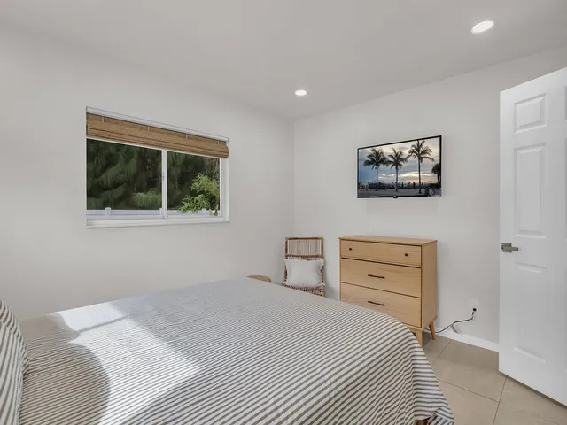 a bedroom with a bed and a painting on the wall