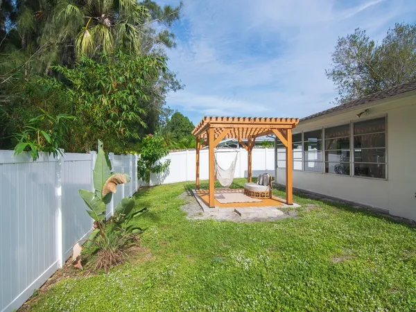 a view of a house with backyard and sitting area