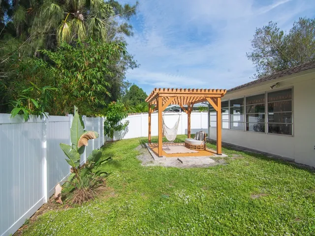 a view of a house with backyard and sitting area