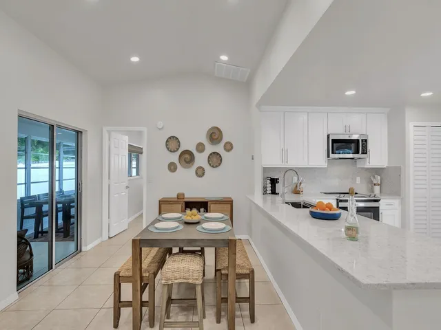 a kitchen with stainless steel appliances a dining table and chairs with wooden floor