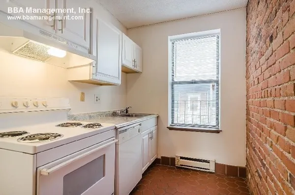 a kitchen with a stove and a white cabinet