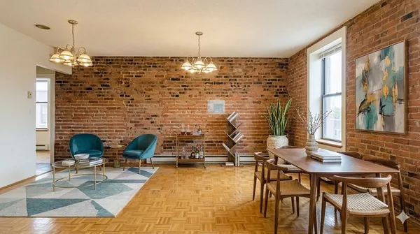a view of a dining room with furniture a chandelier and wooden floor