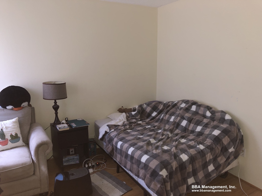 4 Cypress Road, Unit 406 Boston, MA 02135 - Photo 10 of 31 a bed sitting in a bedroom next to a lamp