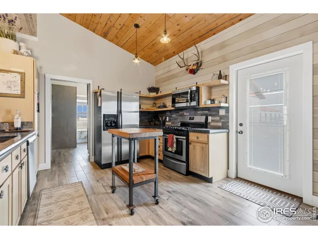 a kitchen with stainless steel appliances granite countertop a stove top oven a sink dishwasher and cabinets with wooden floor