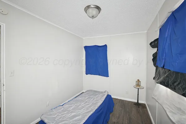a bedroom with a bed and a wooden floor