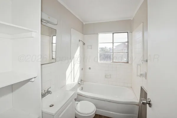 a bathroom with a granite countertop bathtub shower sink vanity and toilet