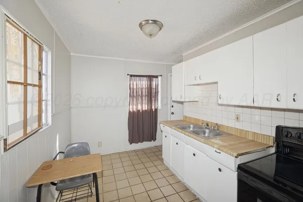 a kitchen with granite countertop a sink stove and cabinets