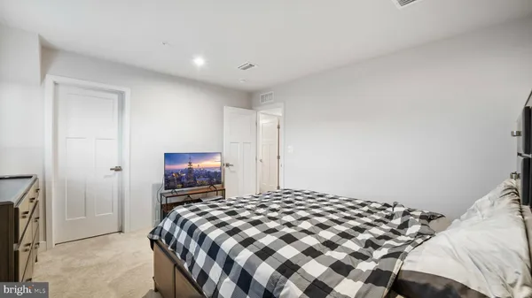 a bedroom with a bed and a painting on the wall