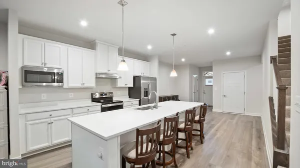 a kitchen with a dining table chairs stainless steel appliances and cabinets