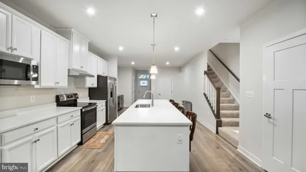 a kitchen with white cabinets and sink