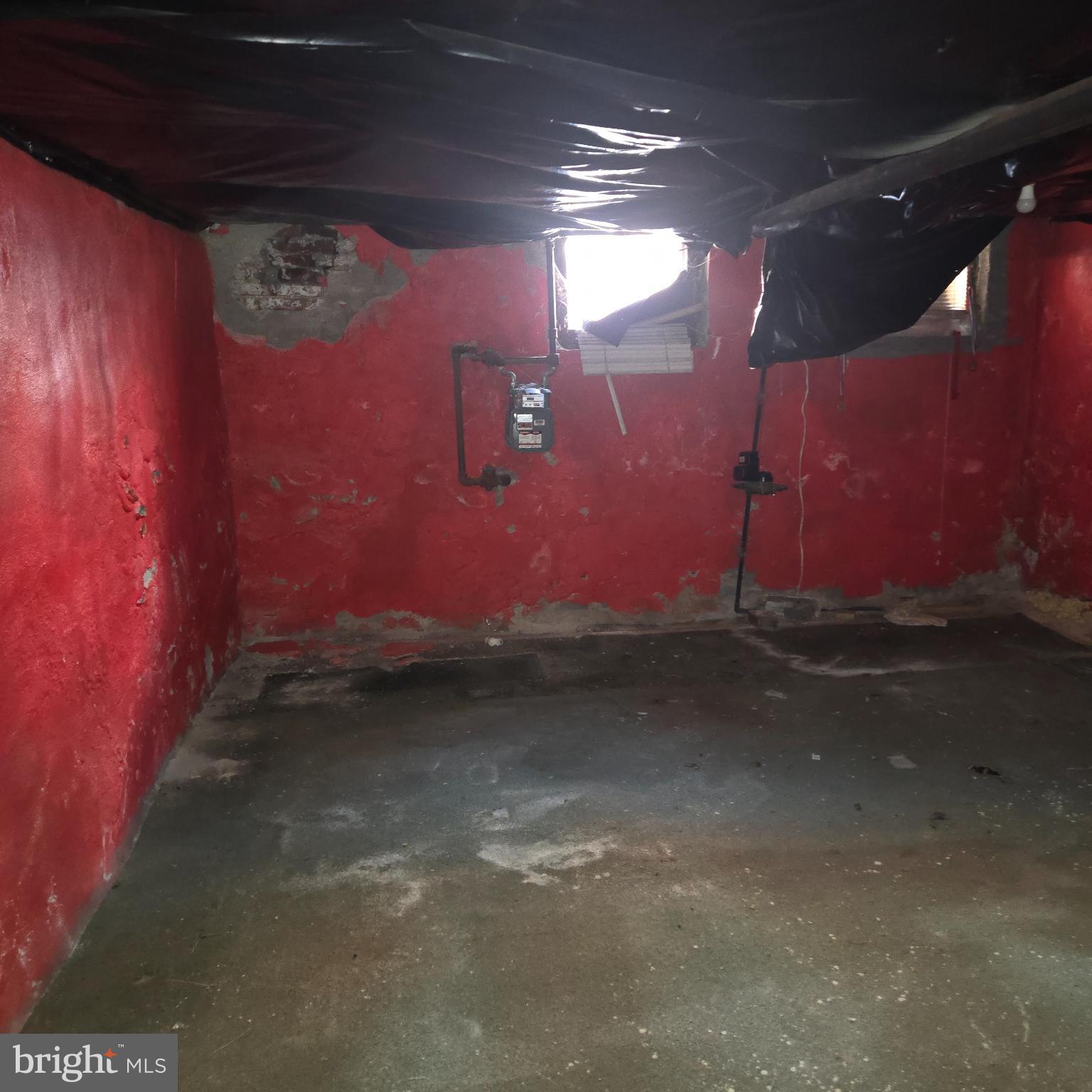 3338 West Sergeant Street Philadelphia, PA 19132 - Photo 10 of 17 Vibrant red walls in a rustic basement space.