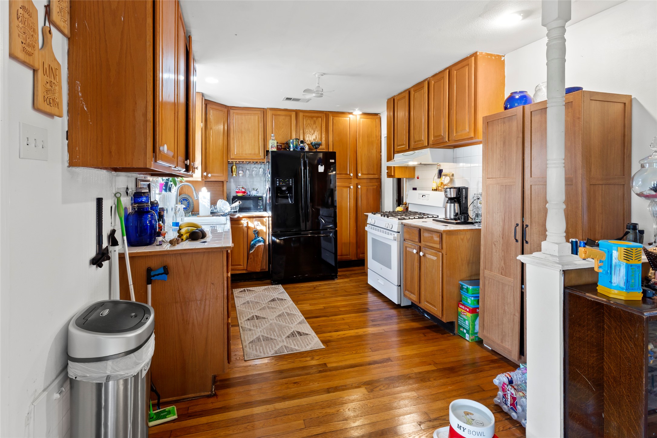 4727 Bland Street Pasadena, TX 77586 - Photo 5 of 17 a kitchen with stainless steel appliances a refrigerator and a wooden floor