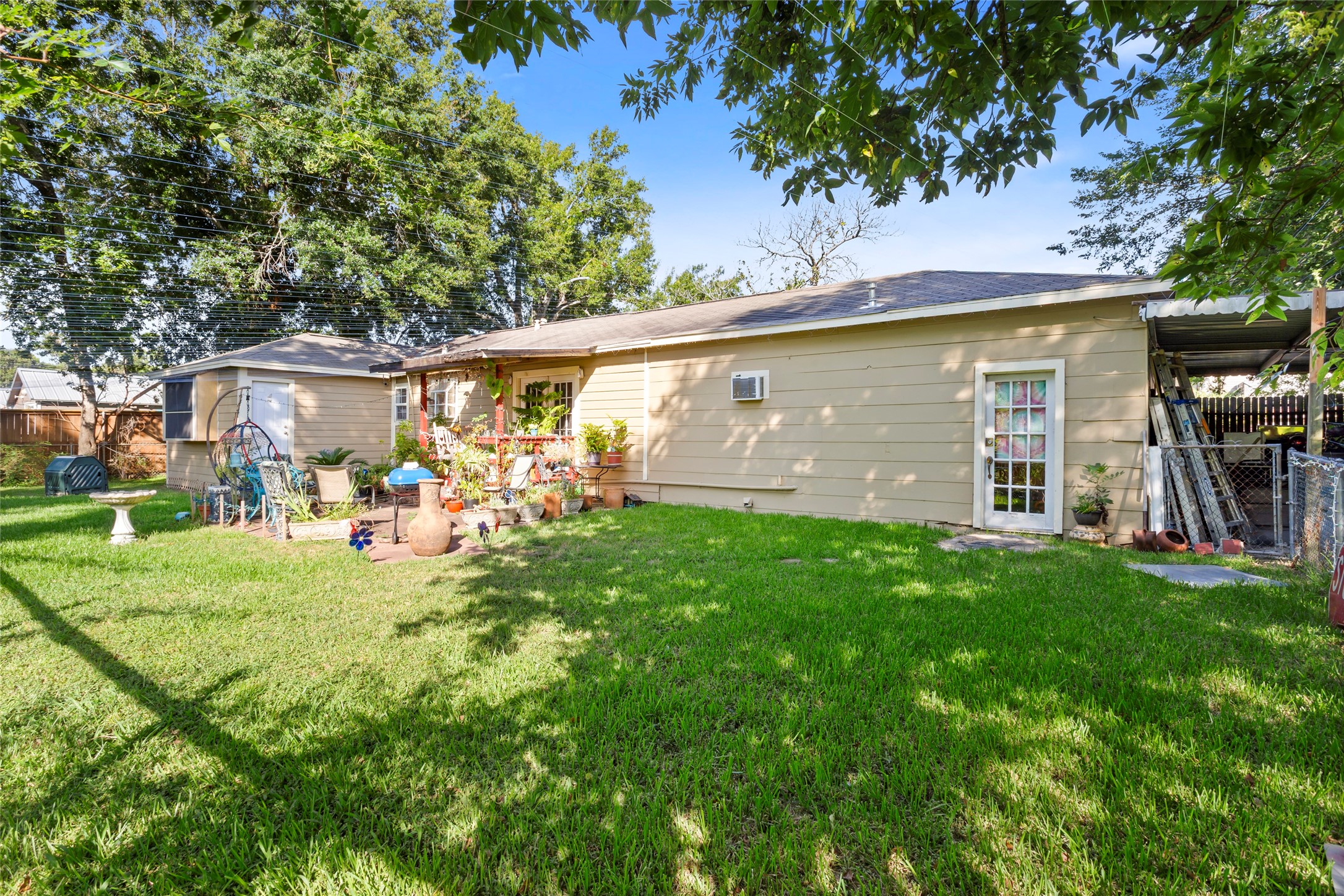 4727 Bland Street Pasadena, TX 77586 - Photo 10 of 17 a view of a backyard with table and chairs potted plants and a large tree