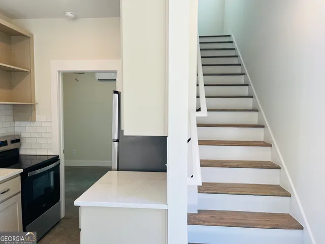 a kitchen with white cabinets and appliances