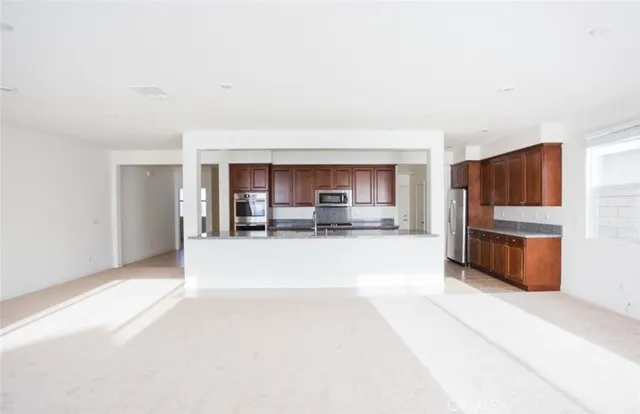 a view of kitchen with stainless steel appliances kitchen island sink refrigerator and stove
