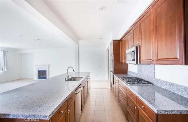a kitchen with granite countertop a sink a stove and cabinets