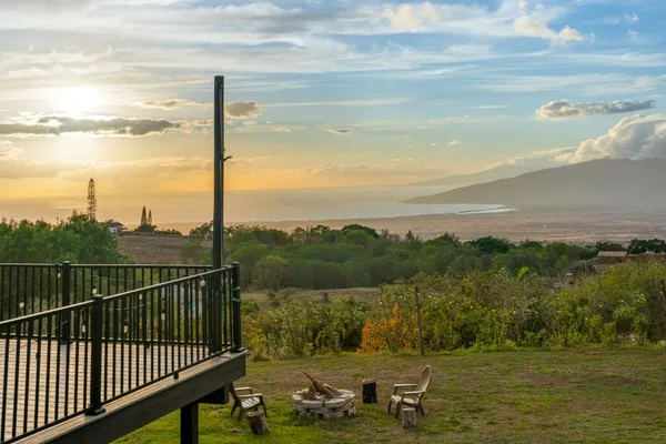 a view of a house with a big yard and large trees