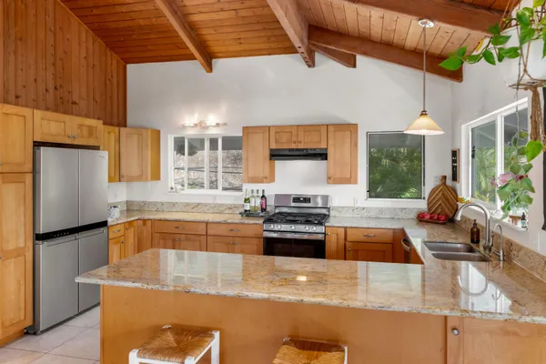 a kitchen with stainless steel appliances granite countertop sink stove and refrigerator