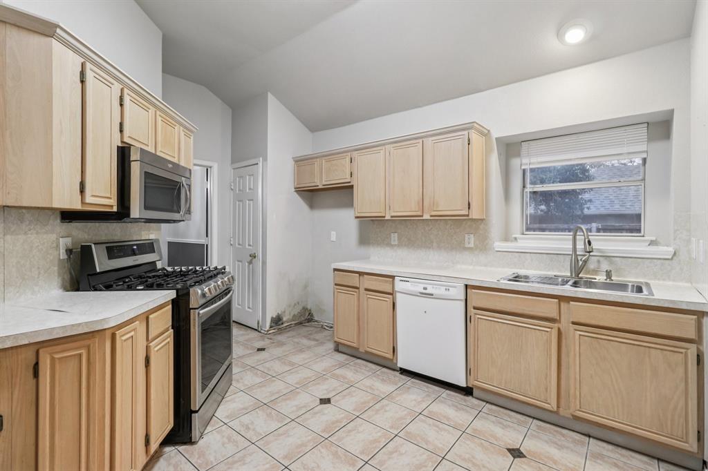600 North Chattey Road DeSoto, TX 75115 - Photo 18 of 40 a kitchen with a sink stove and cabinets