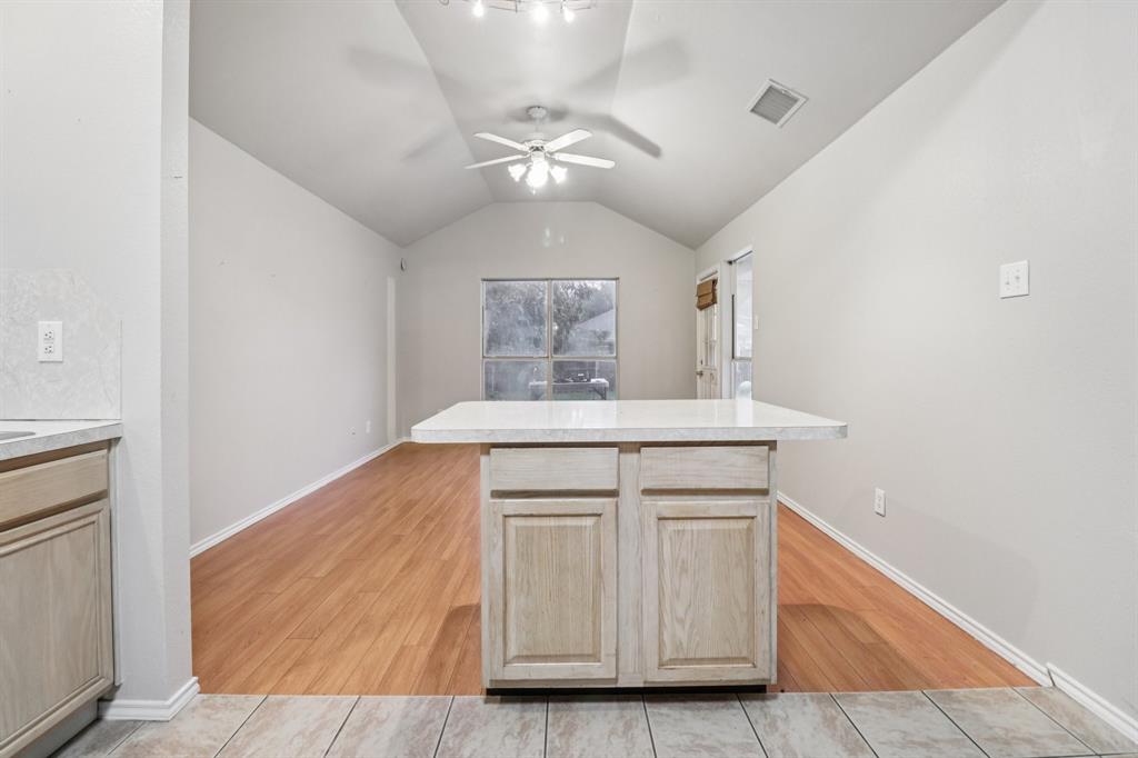 600 North Chattey Road DeSoto, TX 75115 - Photo 21 of 40 a room with kitchen island a ceiling fan and wooden floor