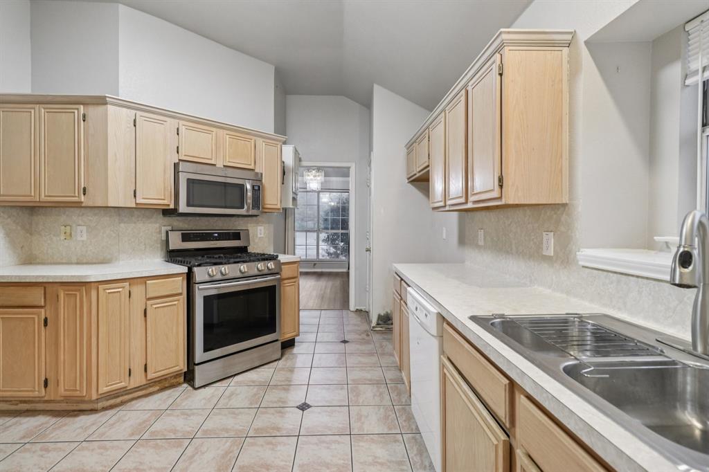 600 North Chattey Road DeSoto, TX 75115 - Photo 5 of 40 a kitchen with granite countertop a sink a stove top oven and cabinets