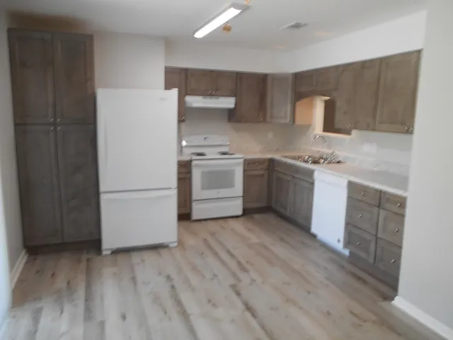 a kitchen with stainless steel appliances a stove a sink and a refrigerator