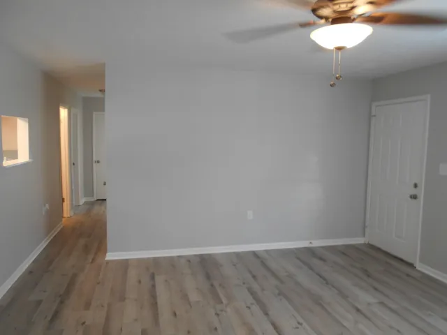a view of a room with wooden floor and a chandelier