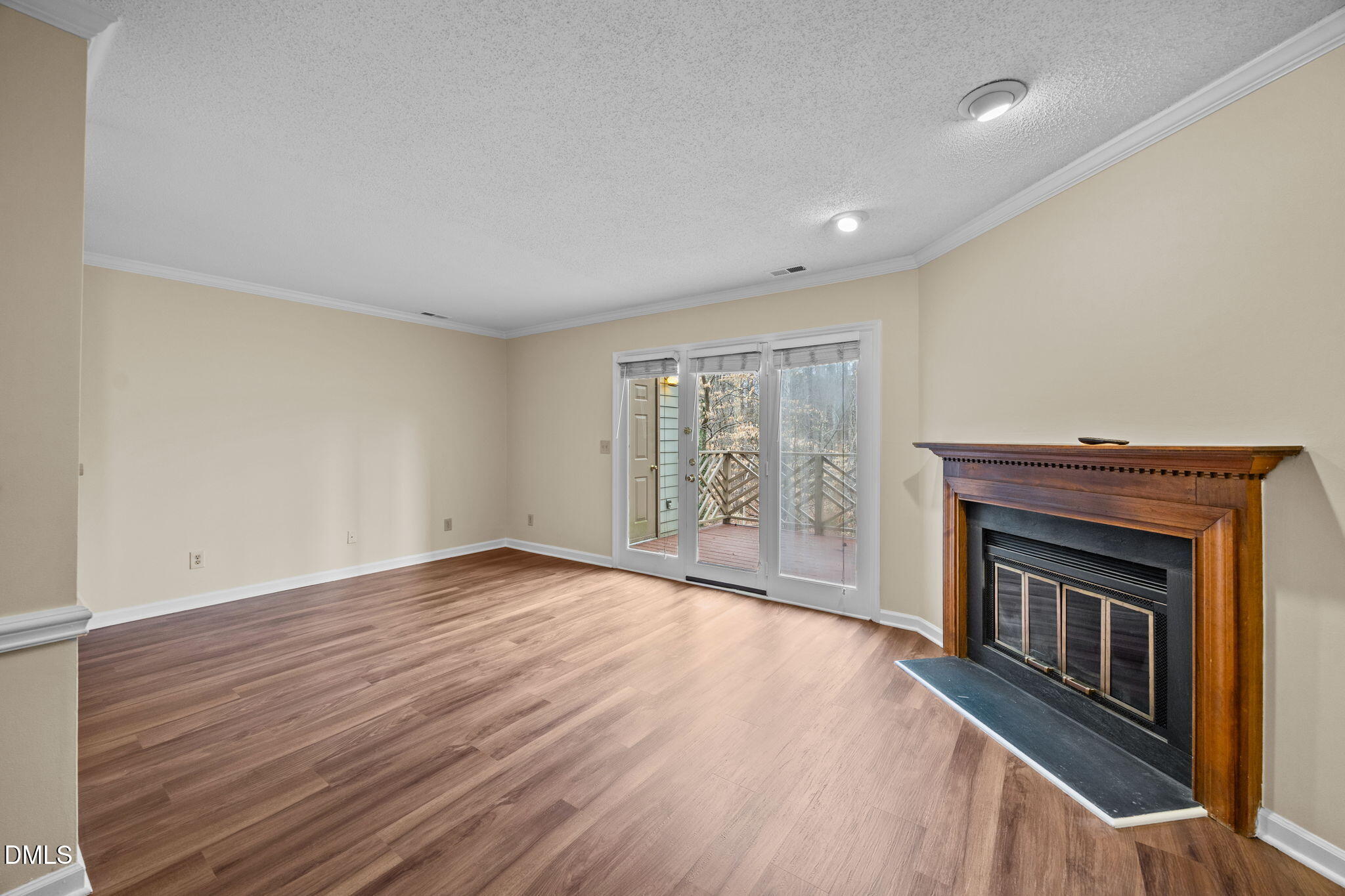 3112 Coachman's Way Durham, NC 27705 - Photo 9 of 32 an empty room with wooden floor fireplace and windows