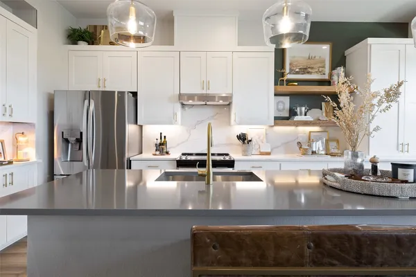 a kitchen with stainless steel appliances granite countertop a refrigerator and a stove top oven