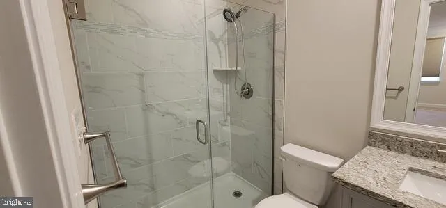 a bathroom with a granite countertop toilet and a shower