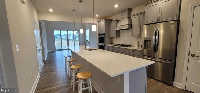 a kitchen with stainless steel appliances a refrigerator and a stove top oven