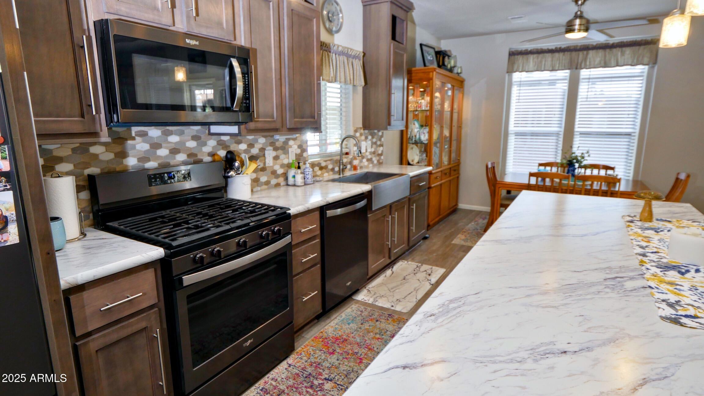 2929 East Main Street, Unit 116 Mesa, AZ 85213 - Photo 7 of 39 a kitchen with stainless steel appliances granite countertop a stove a sink and a microwave